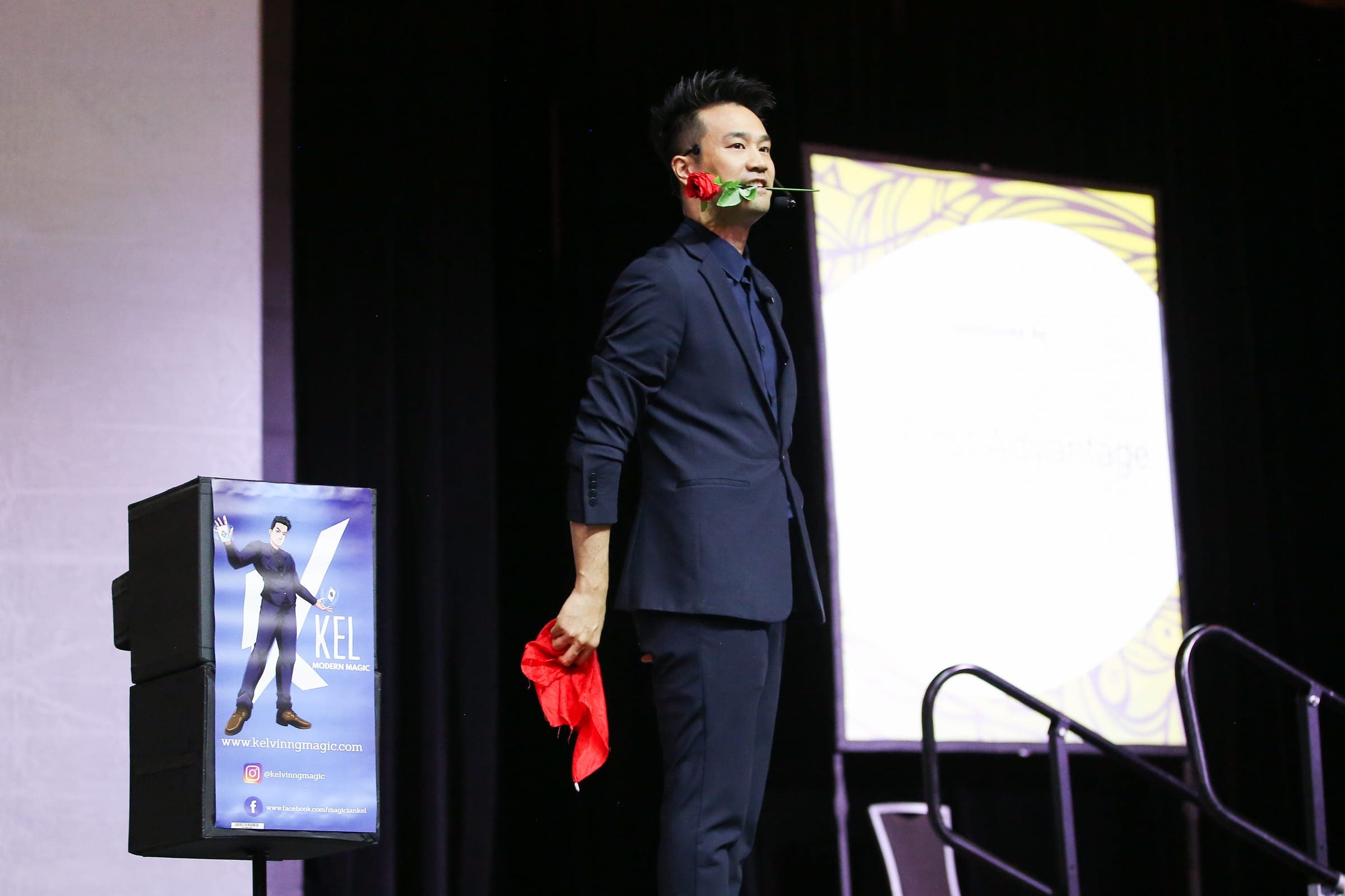 Kel performing a stage routine with a rose at a CPHR conference in Vancouver, close framing