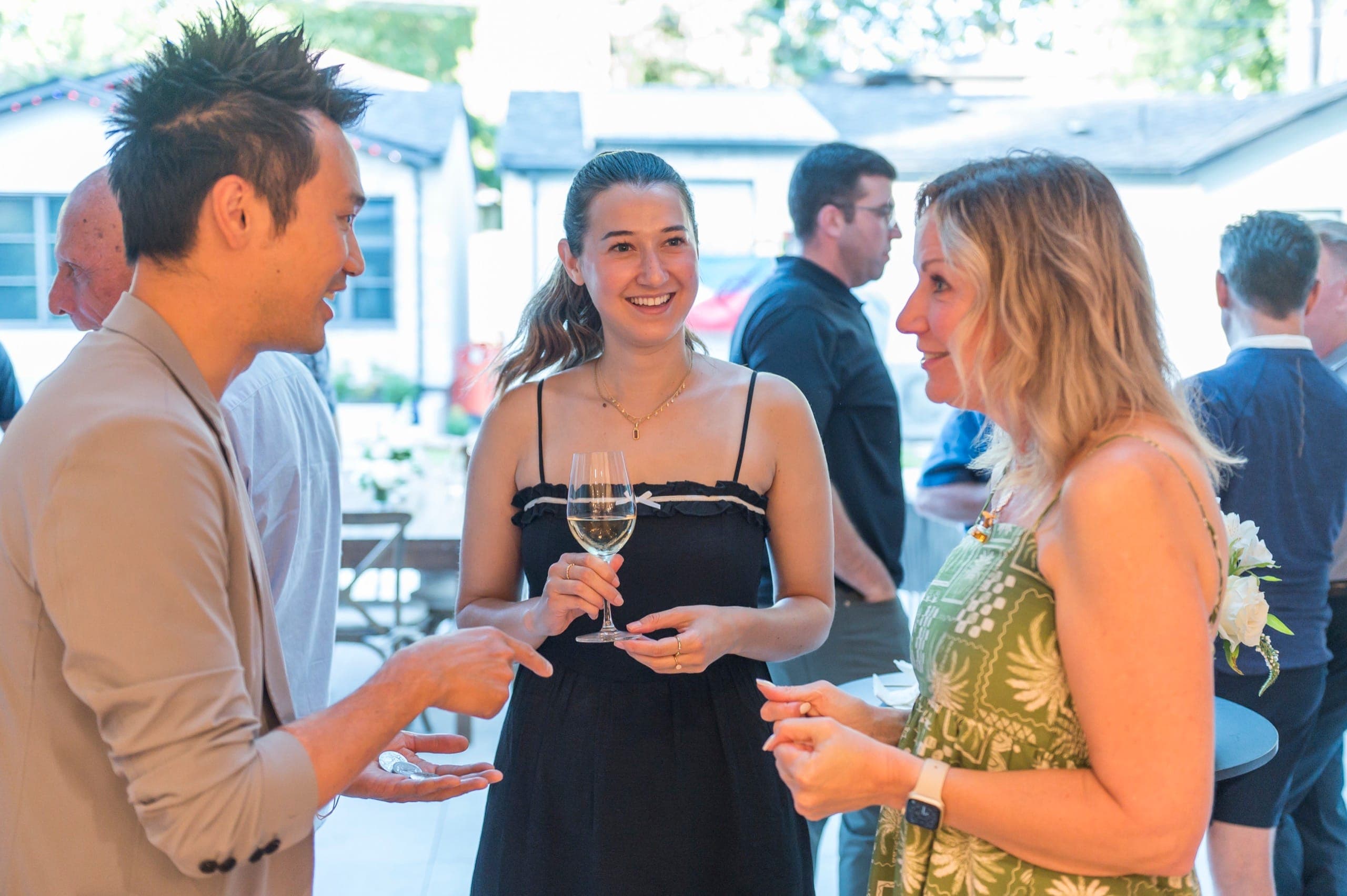 Kel offering coins on an open palm to a guest holding a glass of wine during drinks