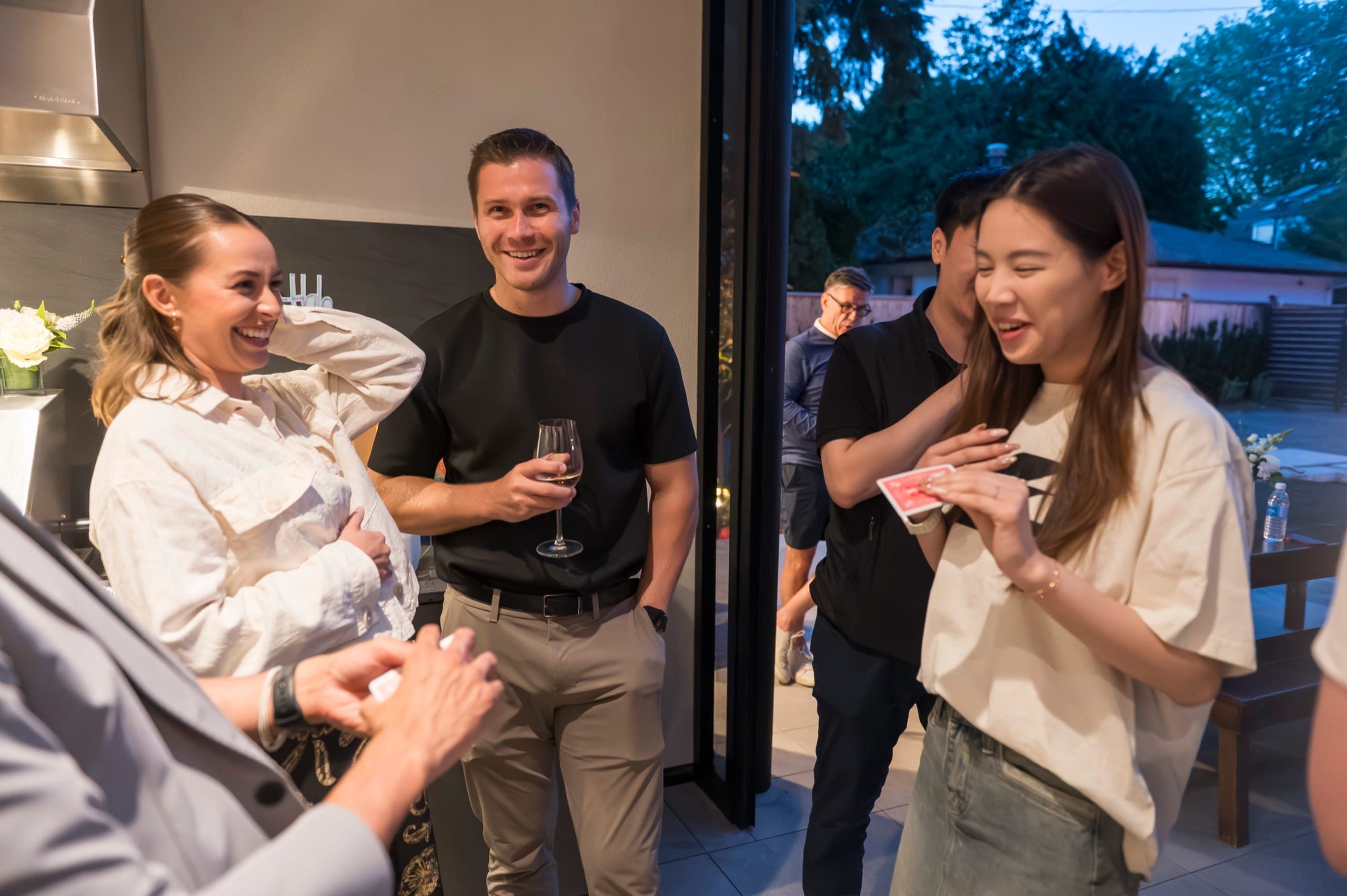 A guest laughing with her hand pressed to her chest as she holds up the card she chose