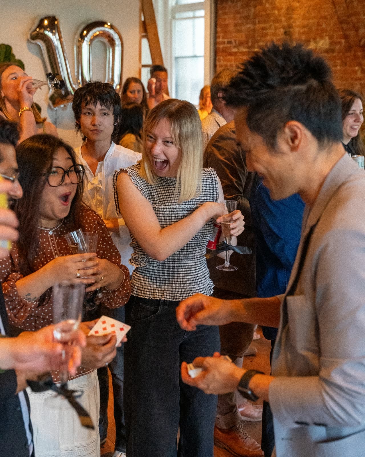 Guests reacting with surprise during close-up magic at Vireo Video's 10 year anniversary party in Vancouver
