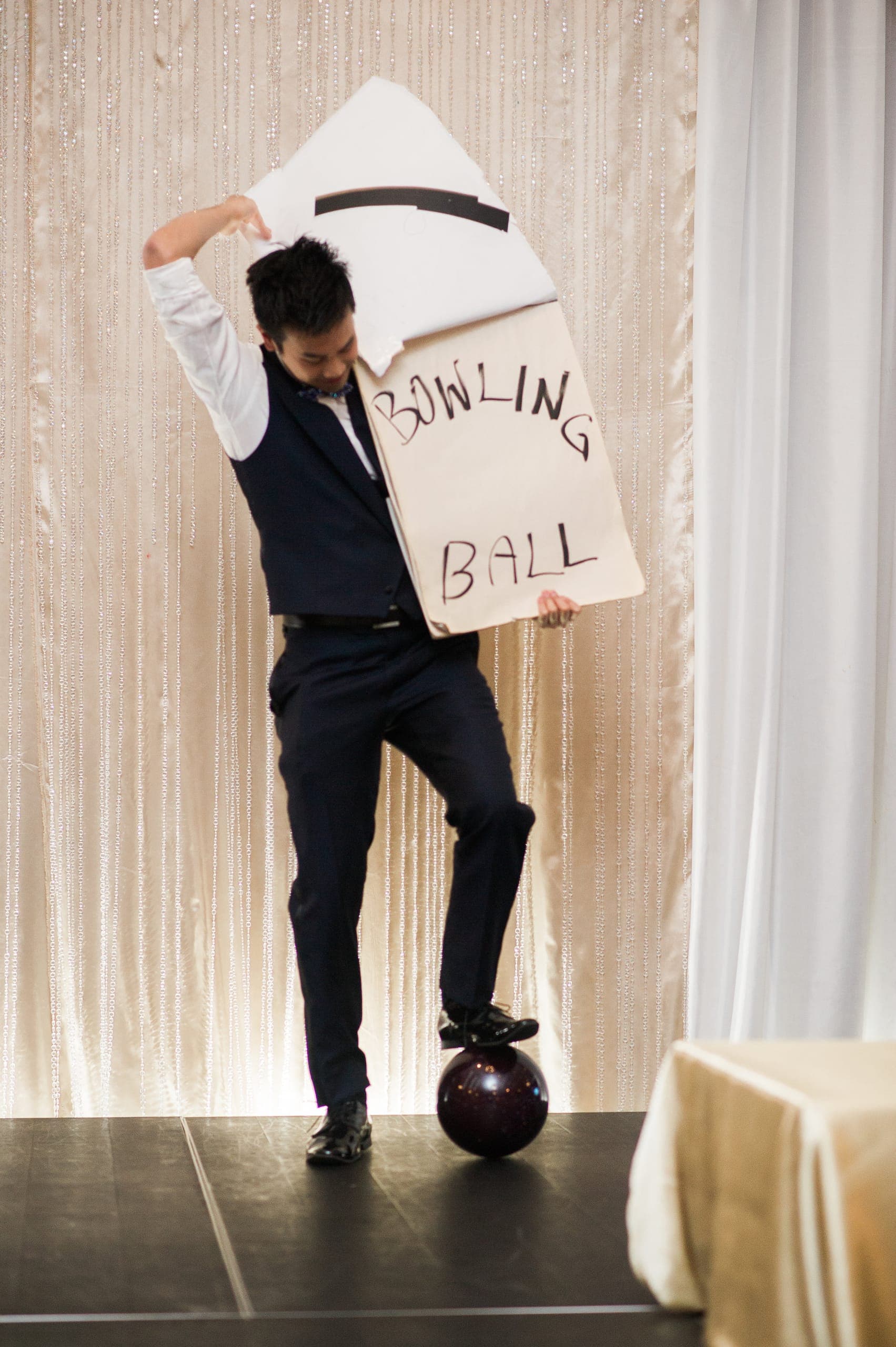 Kel revealing a written prediction on stage at a corporate evening event