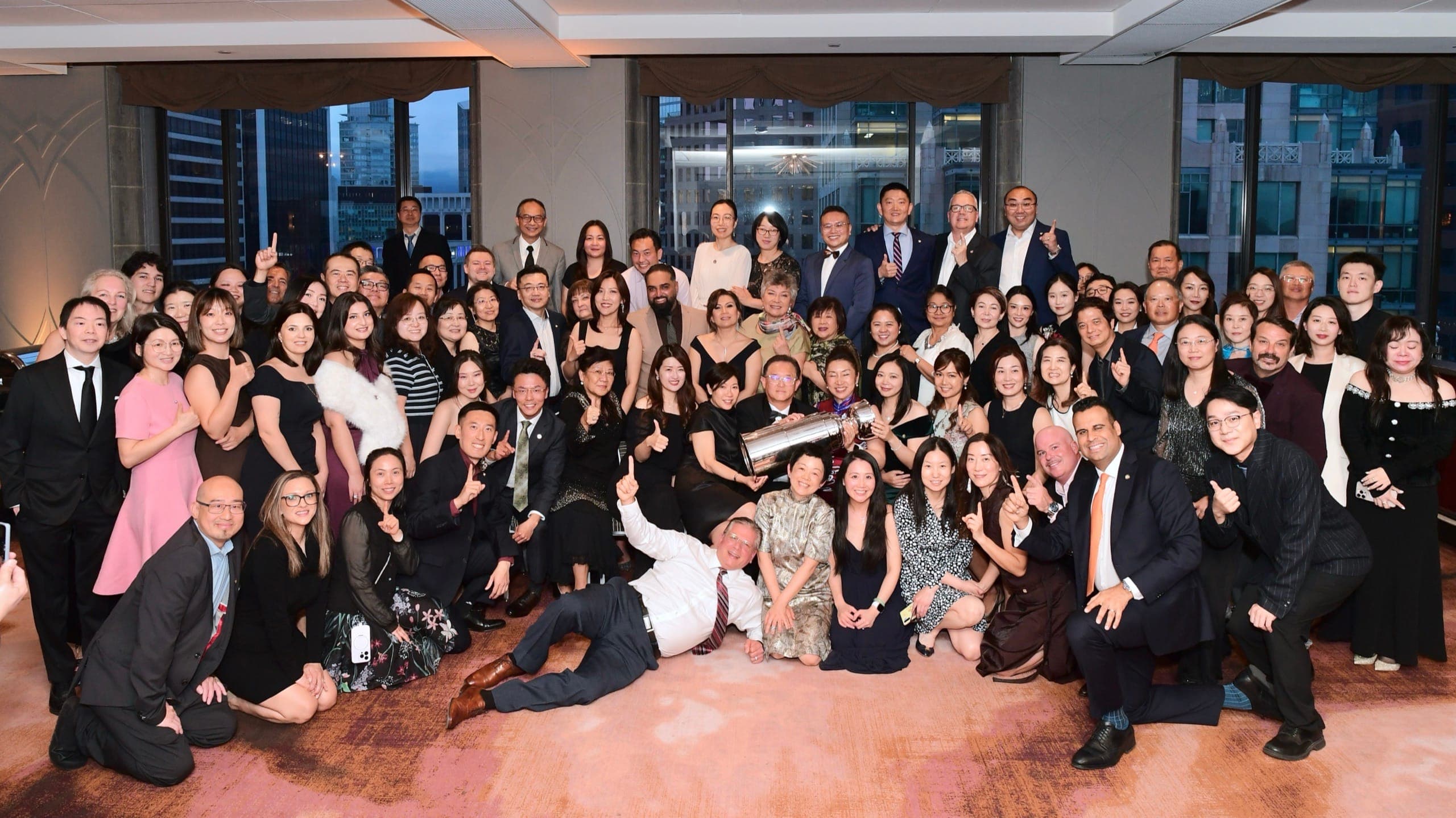 A large room of event guests gathered together at the end of the evening