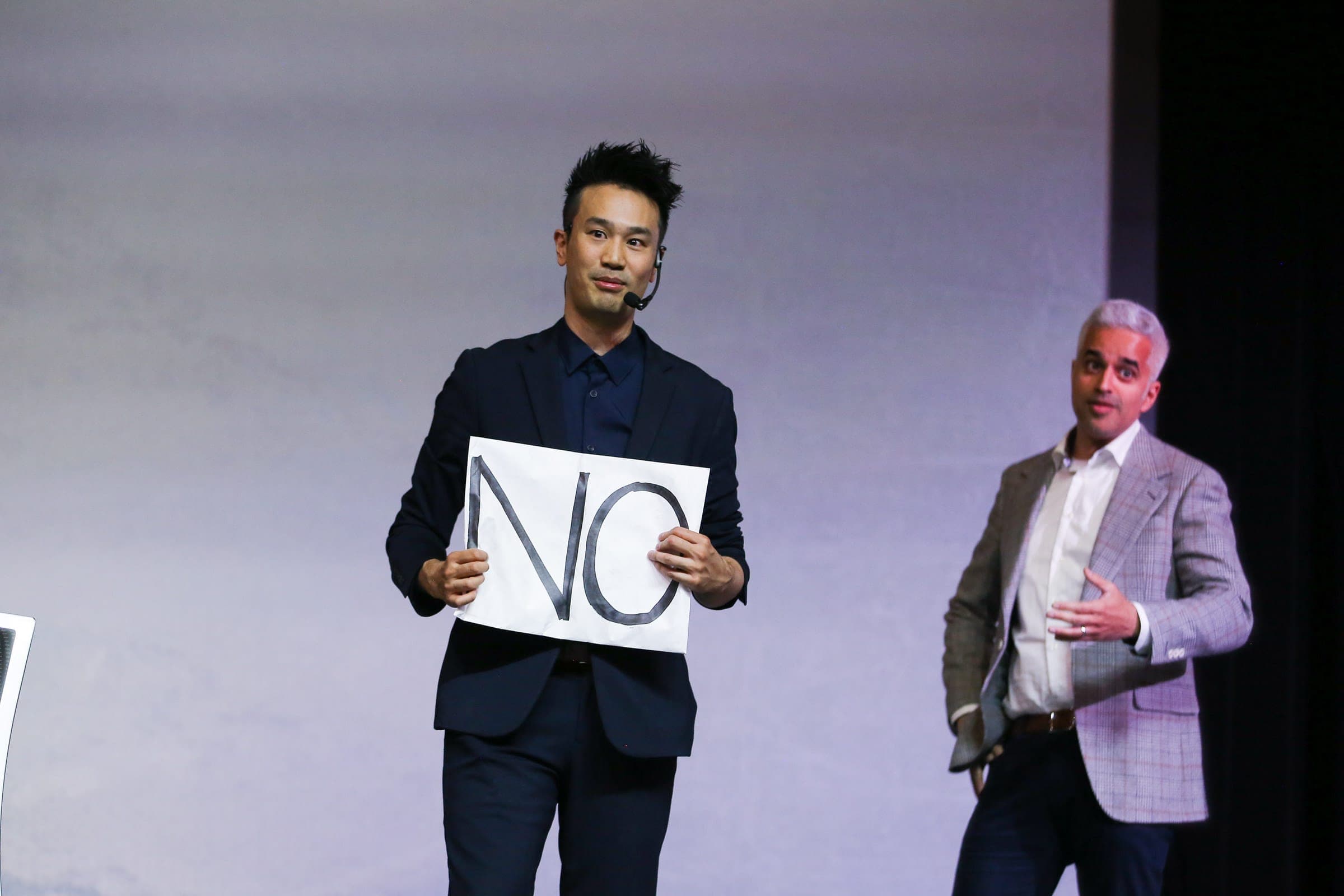 Kel performing on a conference stage to a seated audience in Vancouver