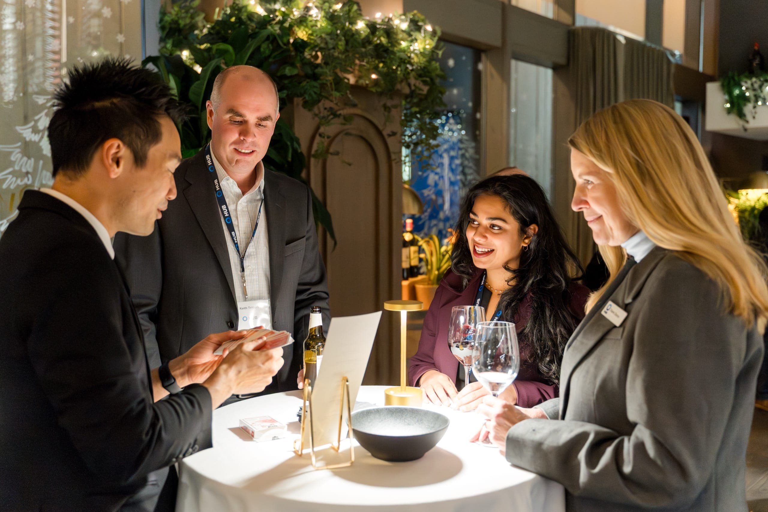 Kel performing close-up magic at a cocktail table for three guests at a Vancouver corporate reception
