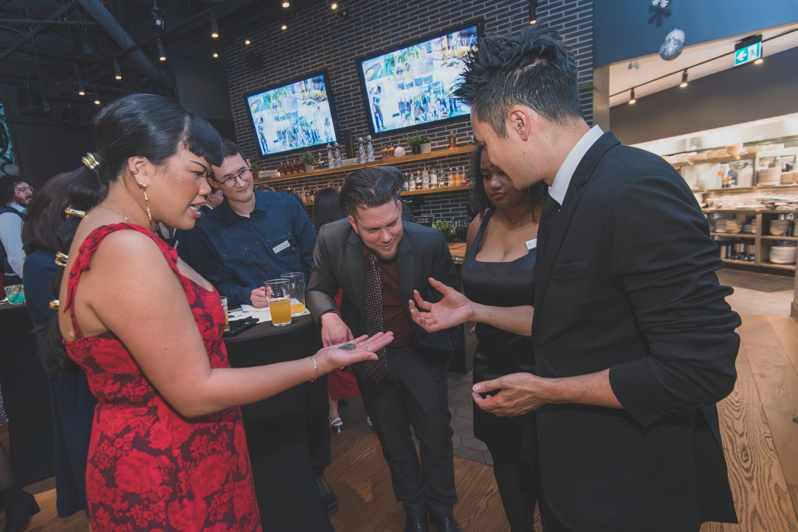 Kel performing a coin routine for guests at a corporate reception