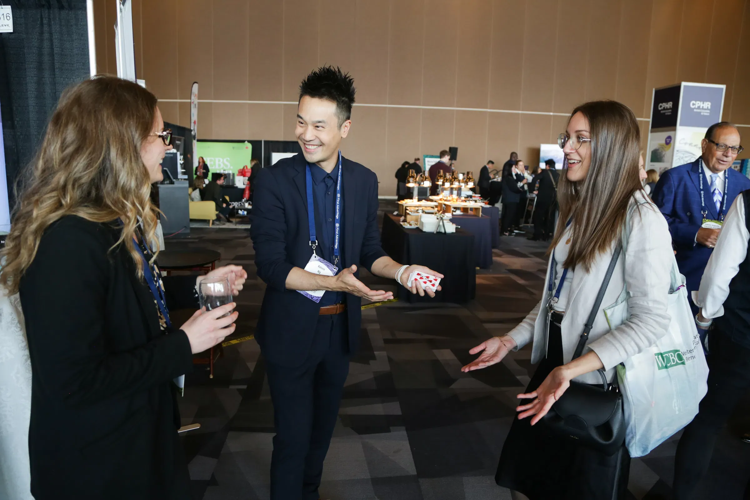 Corporate guests in business attire reacting to close-up magic at a Vancouver conference