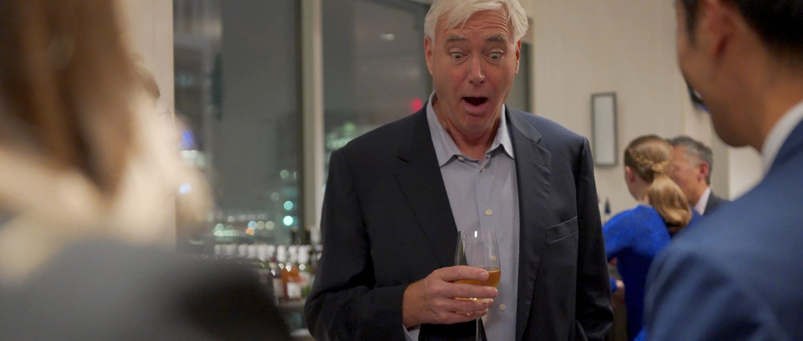 An executive with their jaw dropped during close-up magic at a corporate event