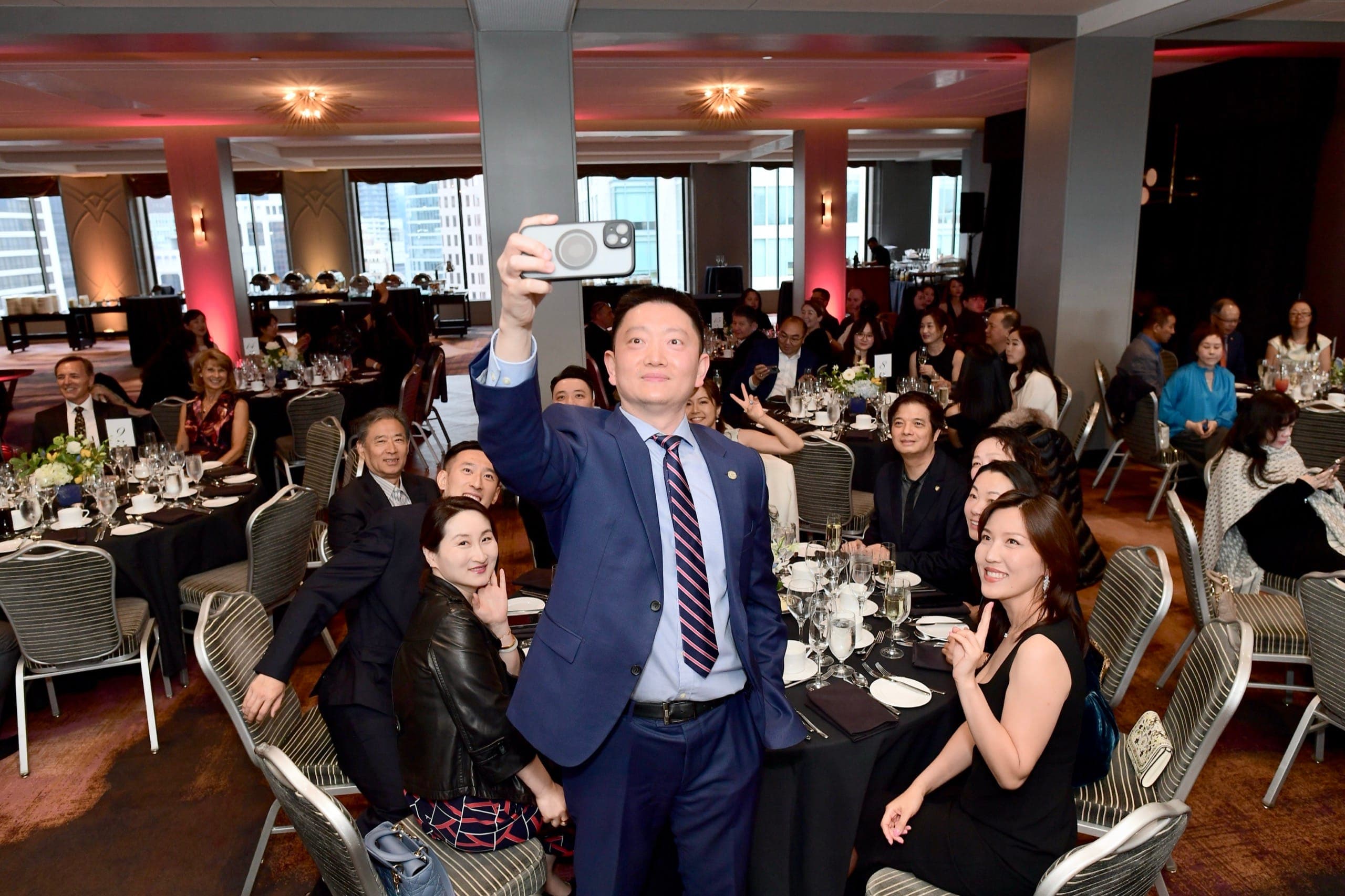Guests crowding together for a group photo during an evening event