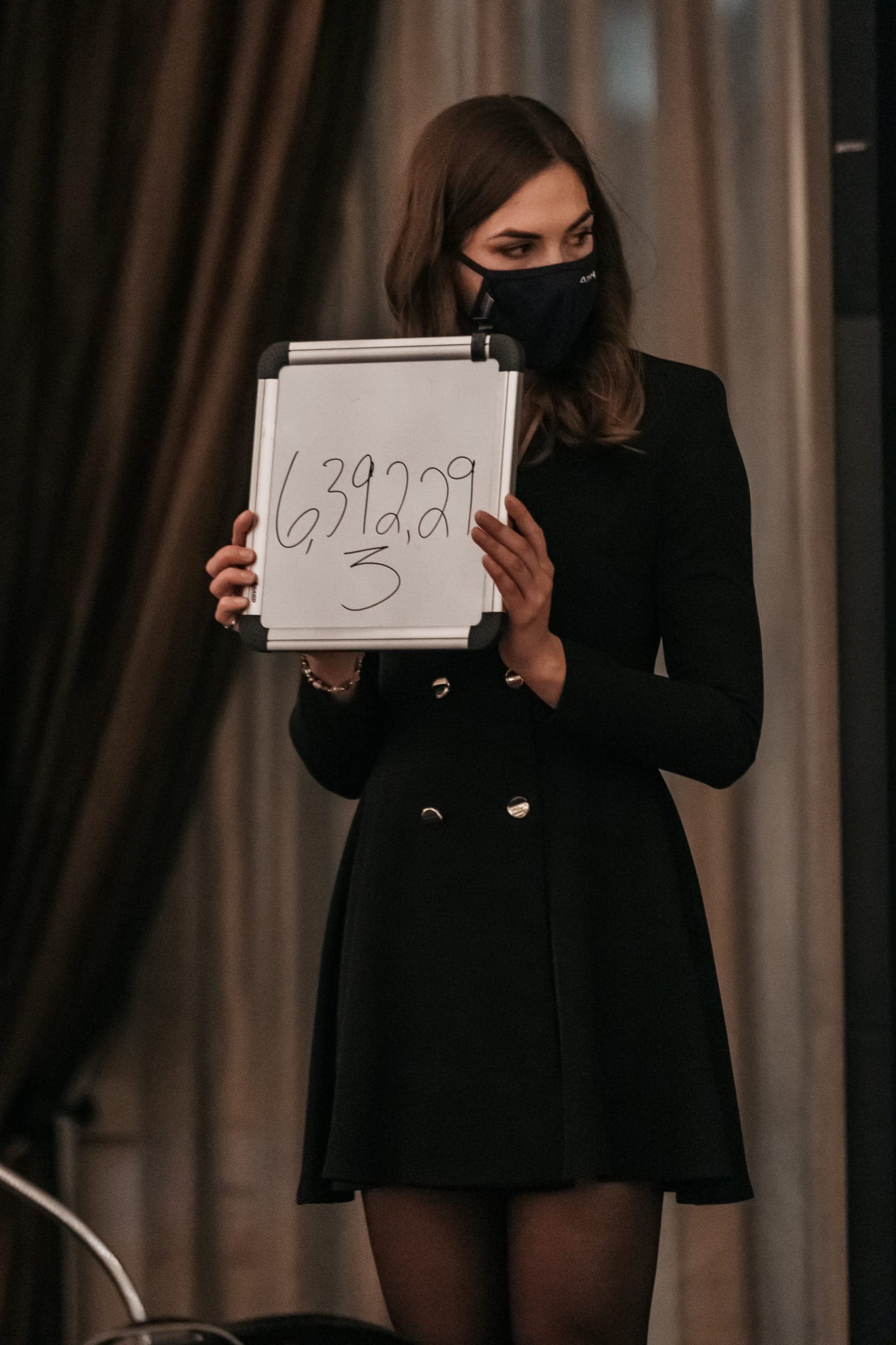 A volunteer holding up a number board during a corporate stage show