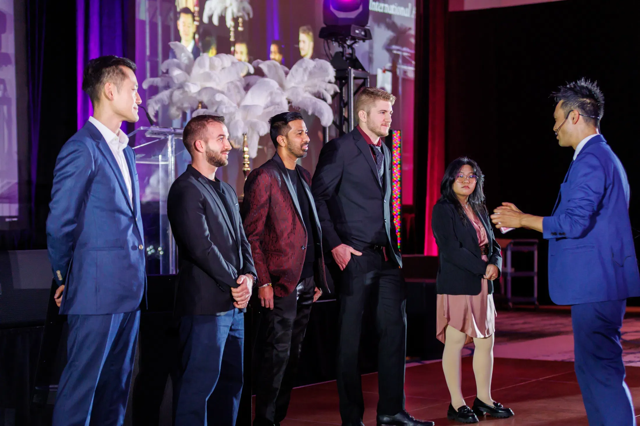 Kel performing close-up card magic for a small group of volunteers on stage at the Hyatt Regency Vancouver