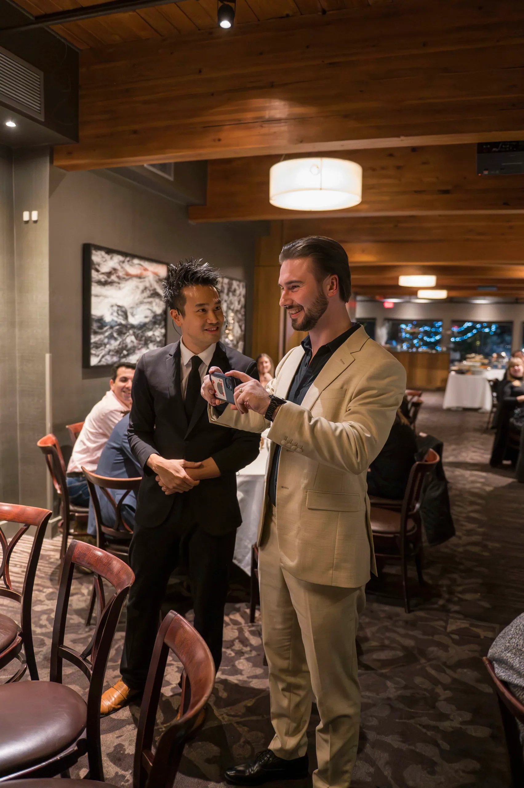 Magician and MC engaging a guest with a card trick at a private Vancouver event