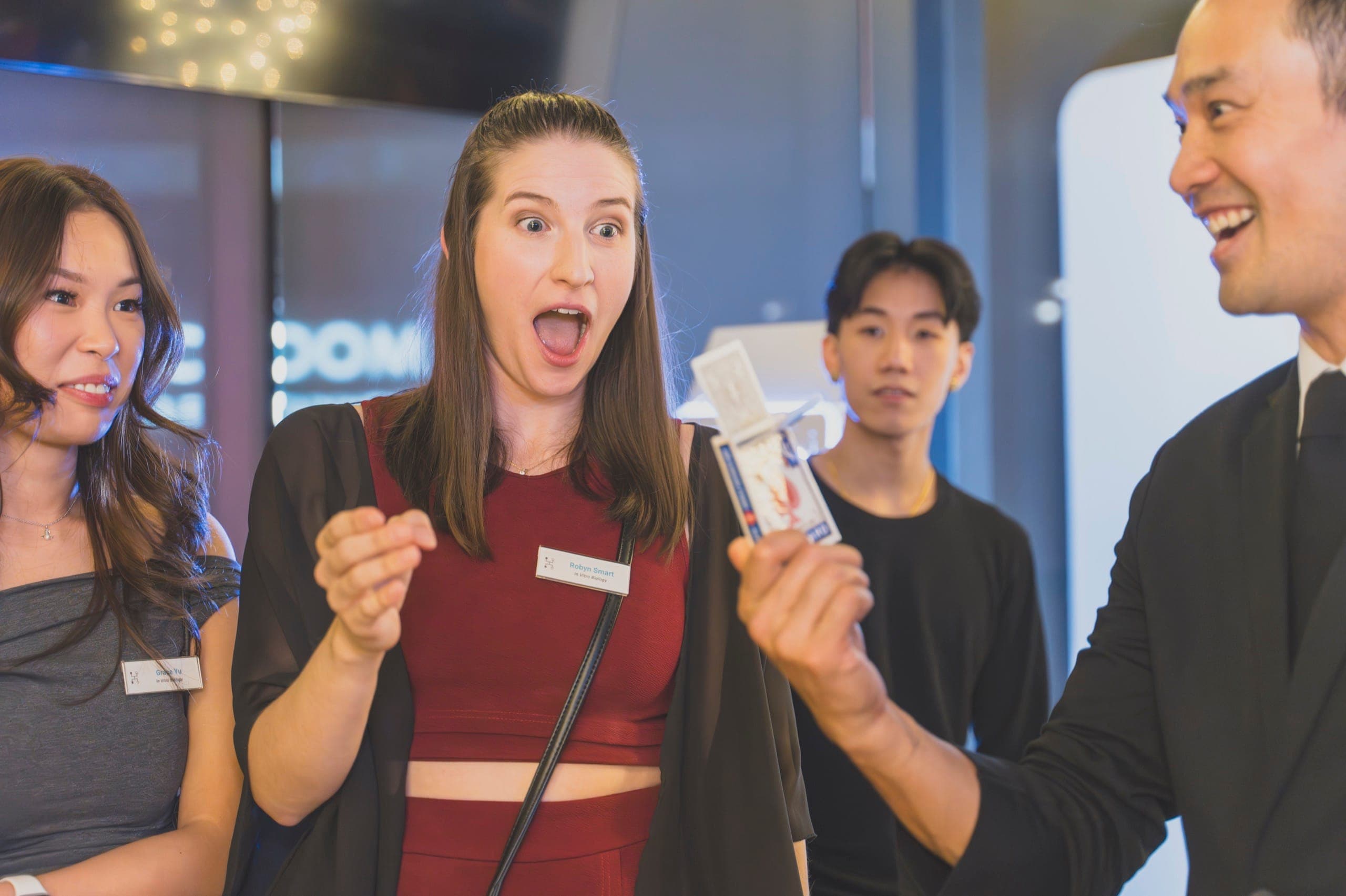 A Xenon Pharmaceutics employee reacting with shock to a card reveal at a Vancouver holiday party