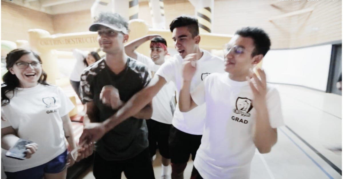 A group of grads laughing and reacting to close-up magic at a Vancouver dry grad event
