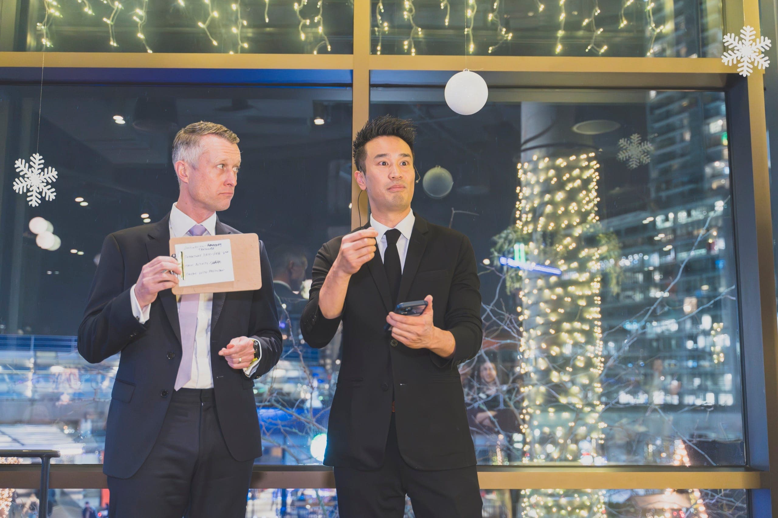 Kel revealing a prediction with an executive against Vancouver city lights at a financial services event