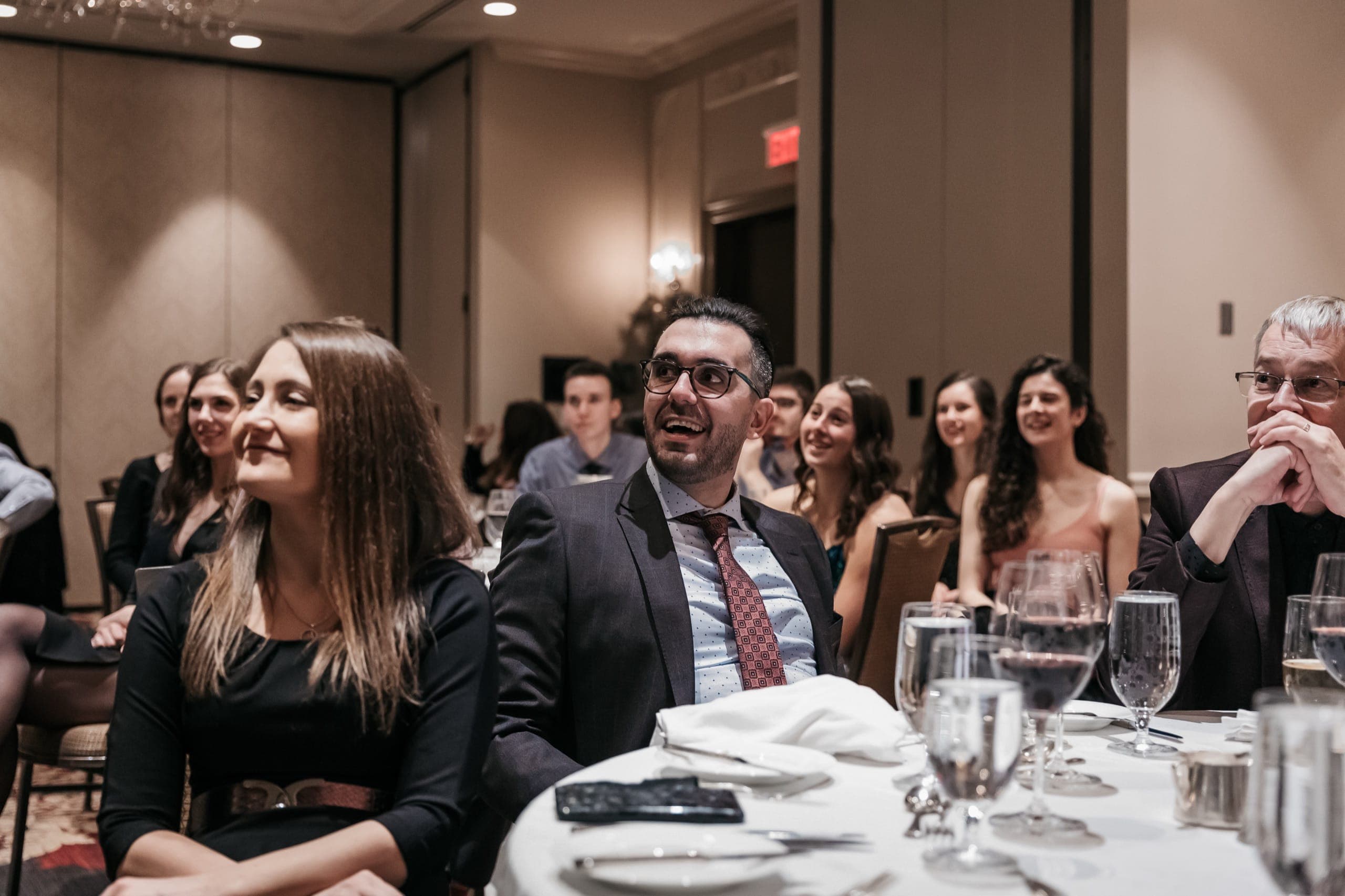 A row of seated guests laughing during a magic performance at a Vancouver financial services event