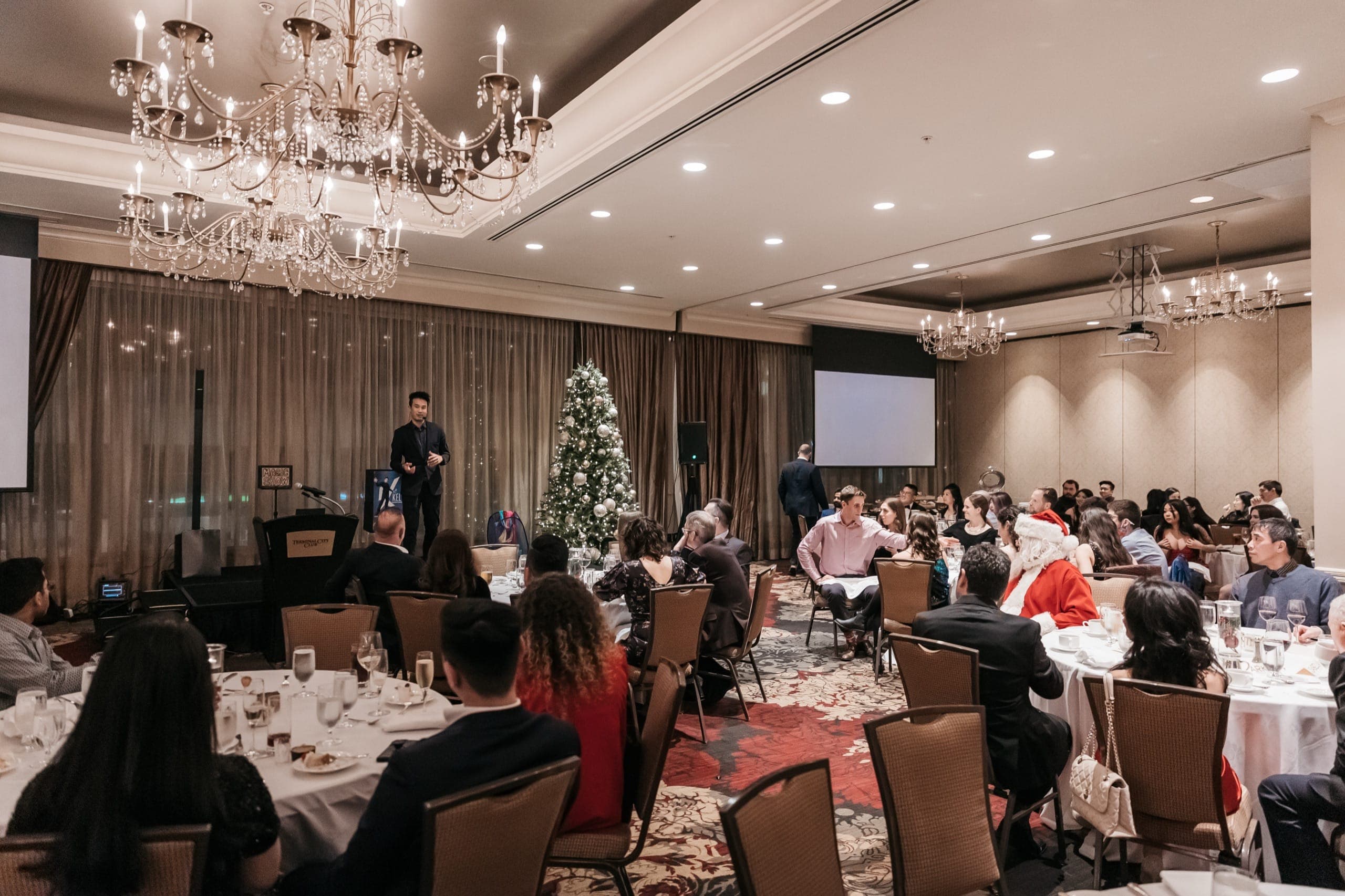 A full gala ballroom under crystal chandeliers, every table seated for the show in Vancouver