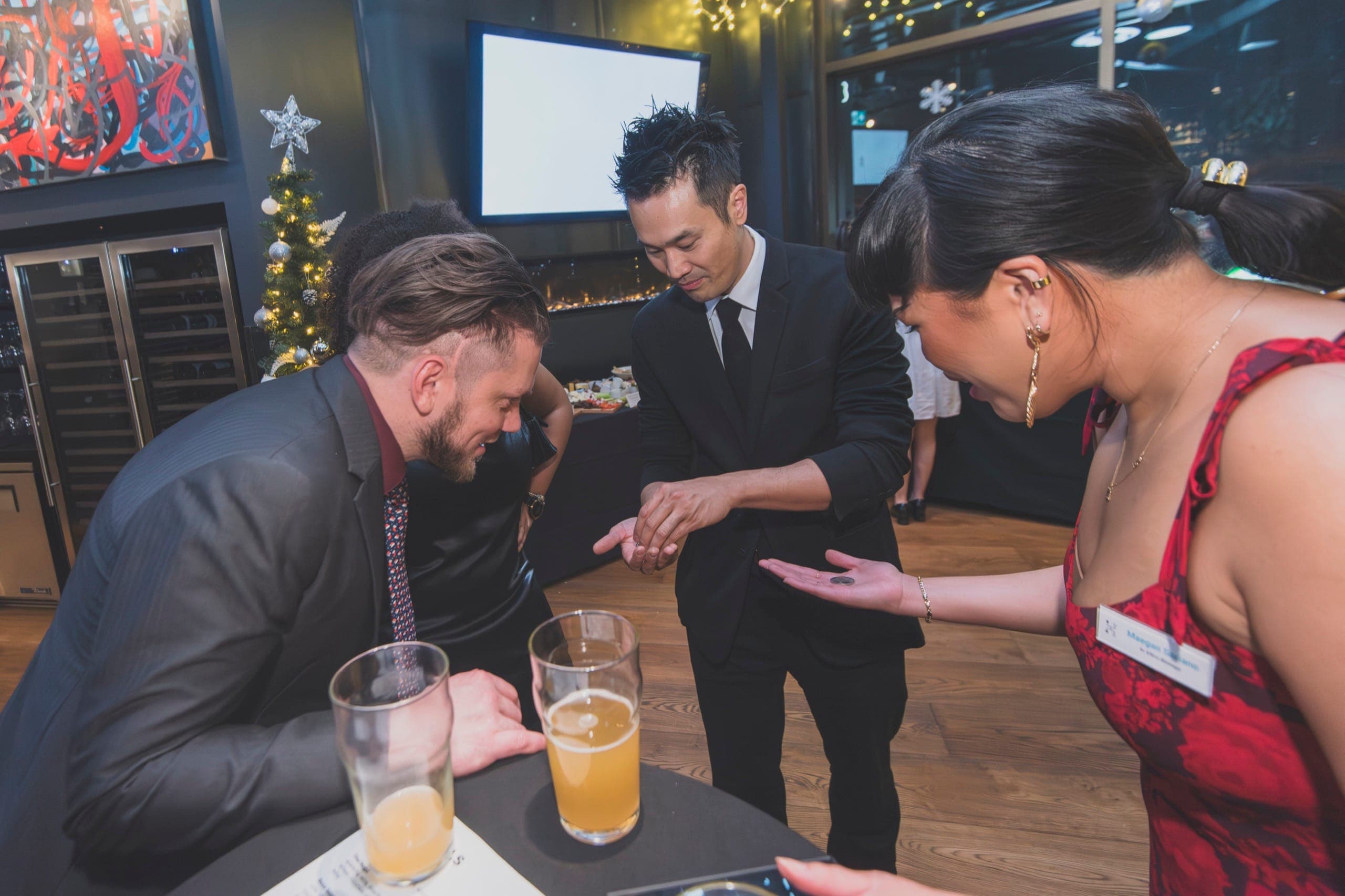 Kel performing a coin routine for guests at a Vancouver law firm holiday reception