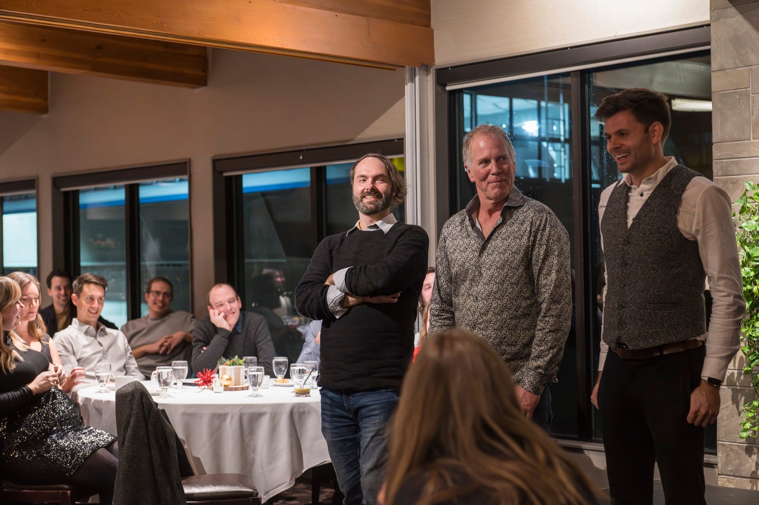 Three volunteers standing for a routine while colleagues watch at a Vancouver law firm event