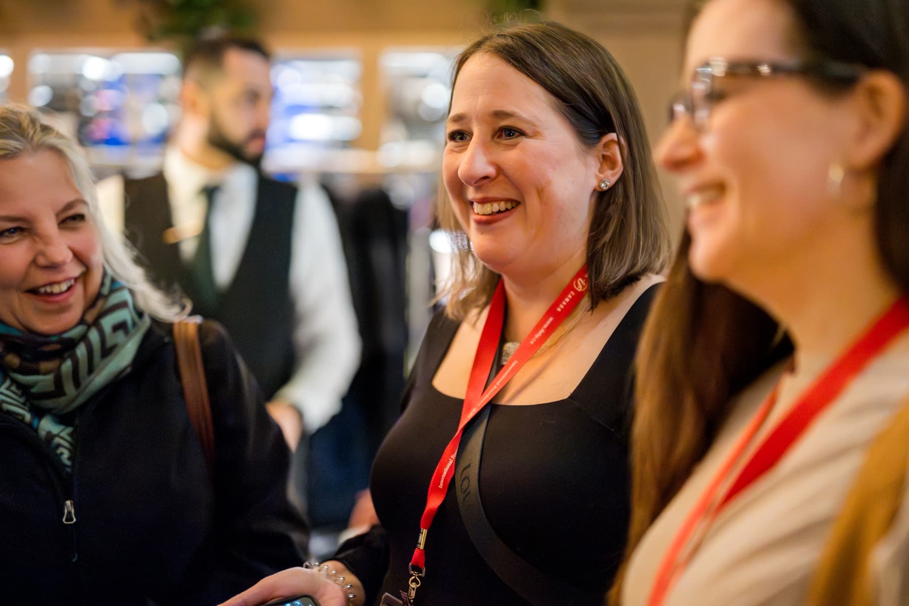 Guests laughing together during close-up magic at a Vancouver corporate reception