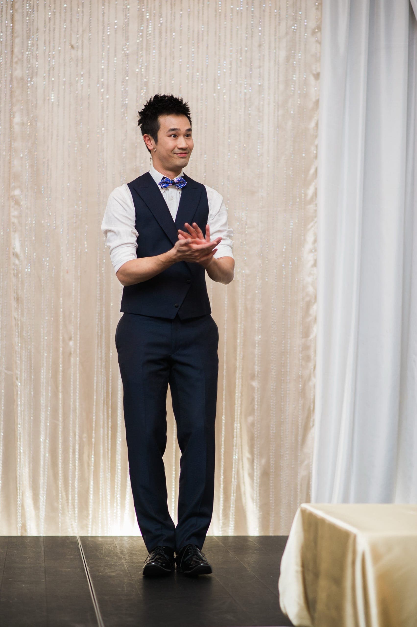 A large room of guests applauding at the end of a stage show at a corporate event
