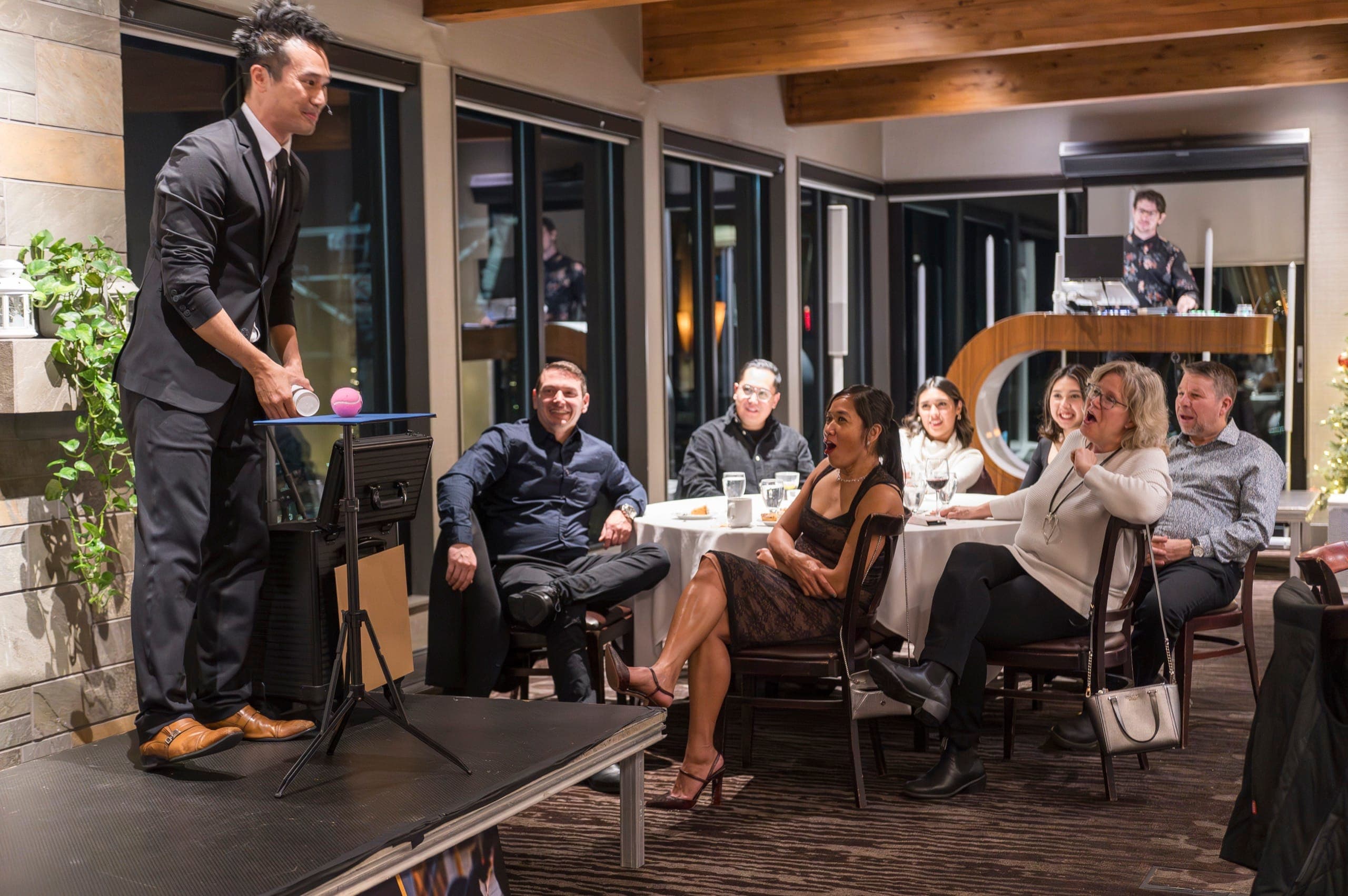 Two guests at a table gasping while Kel performs a routine on stage in Vancouver