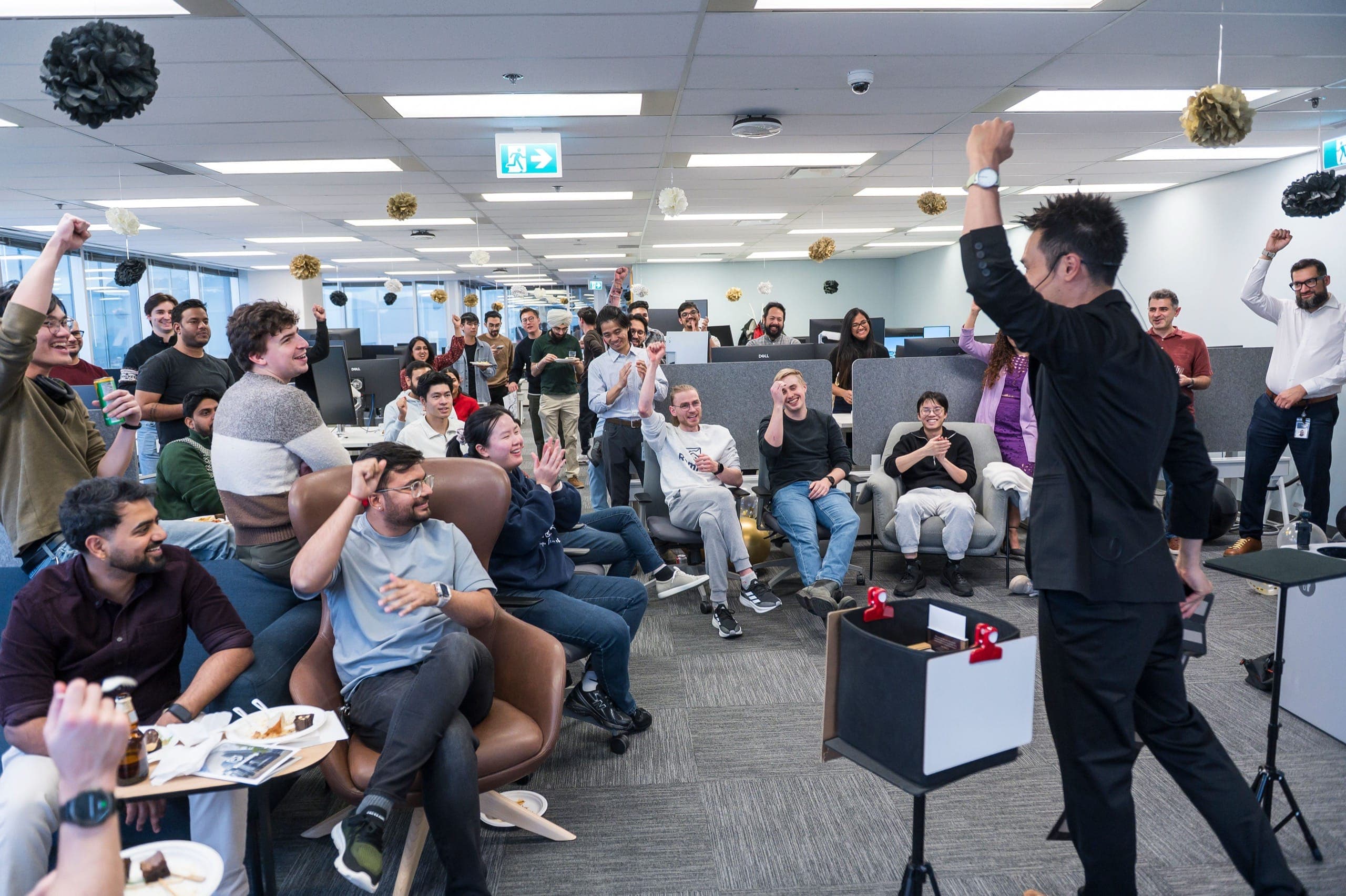 A company floor with fists in the air mid-routine at a Vancouver tech office holiday party