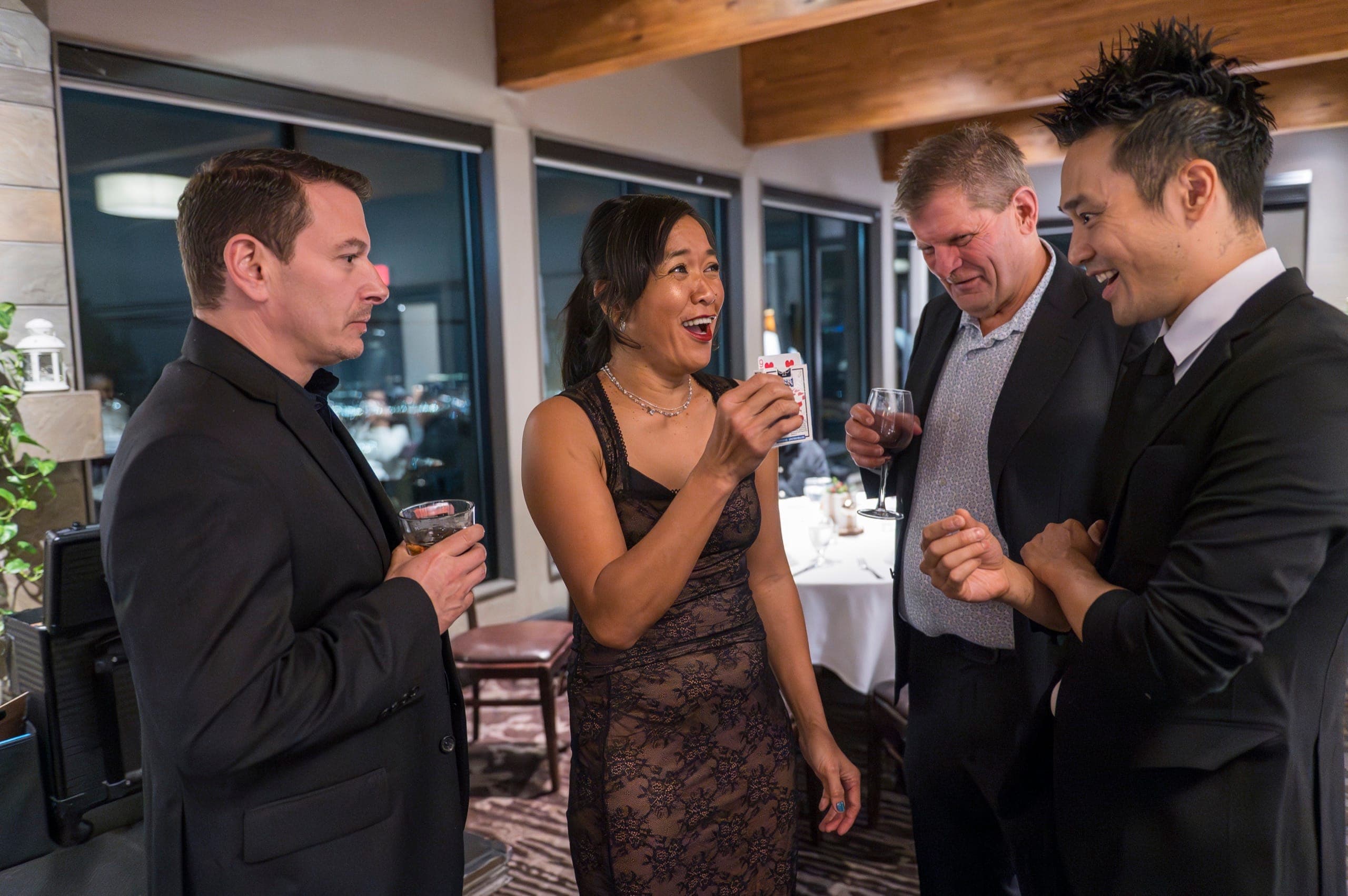 A standing group laughing while a guest holds cards during a Vancouver tech company party