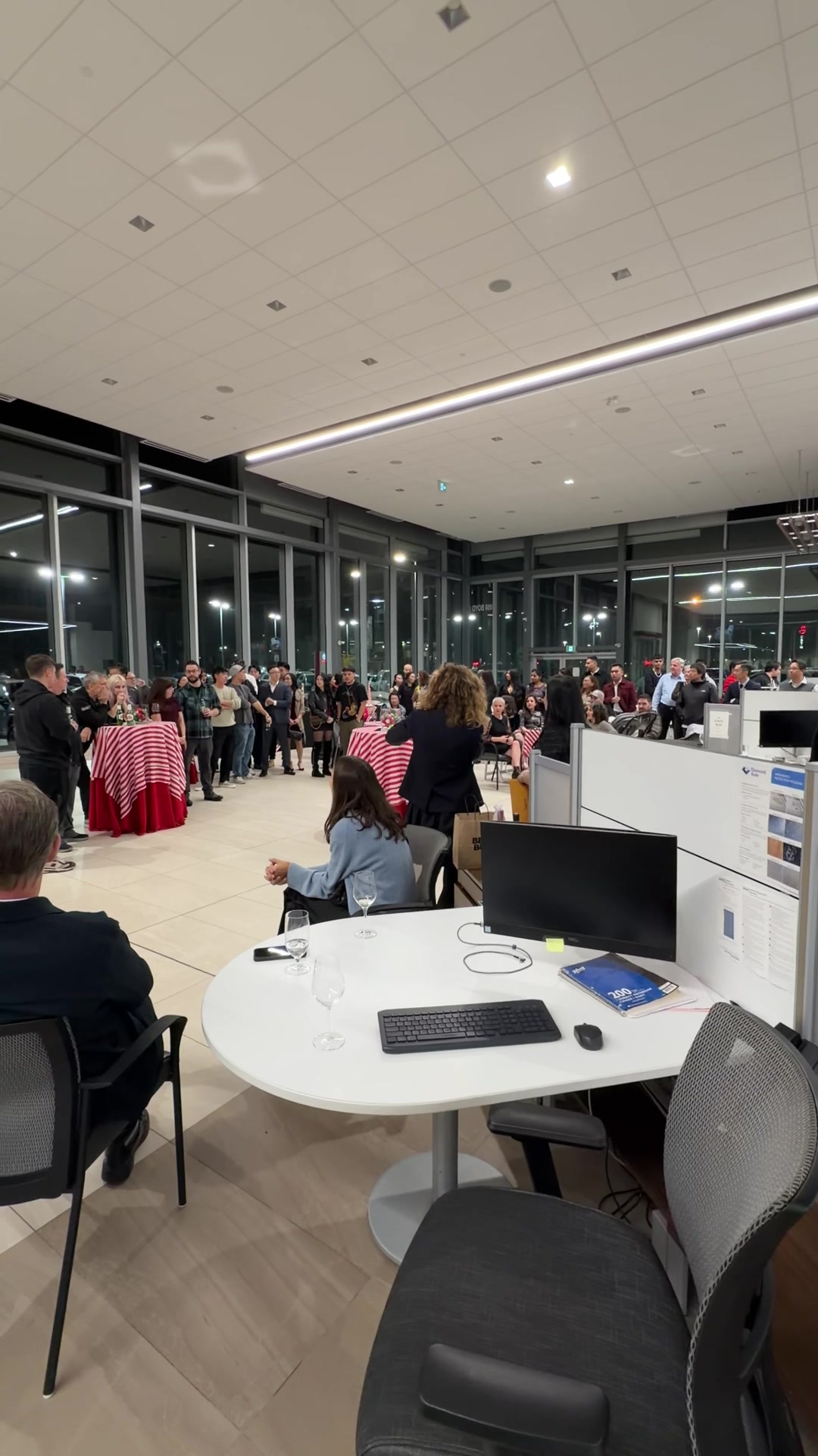 A packed Westminster Toyota showroom at night during the dealership's Christmas party, with guests gathered around red-clothed cocktail tables