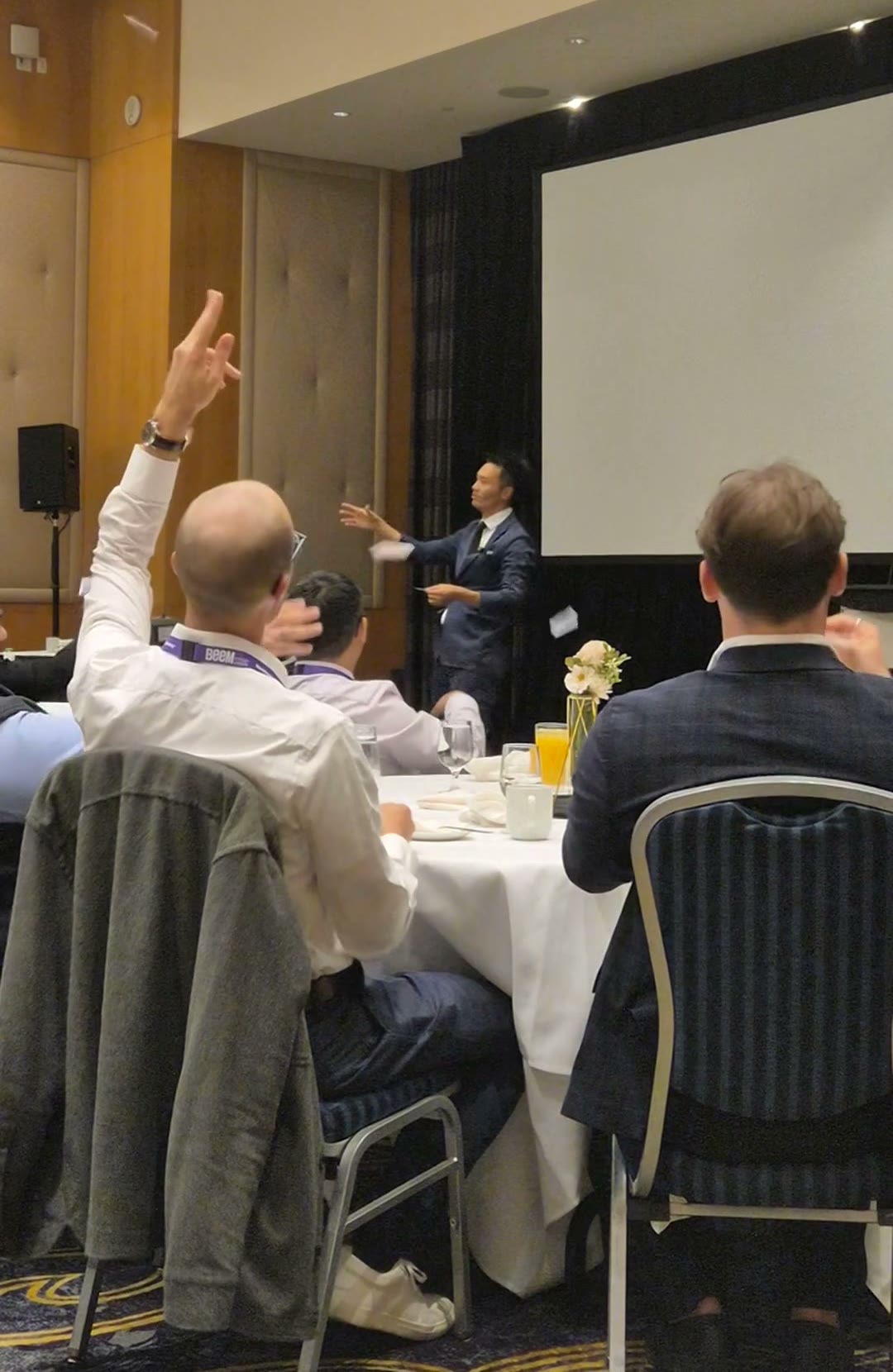 A Beem Wealth guest throwing his hand in the air during Kel's stage show in Burnaby