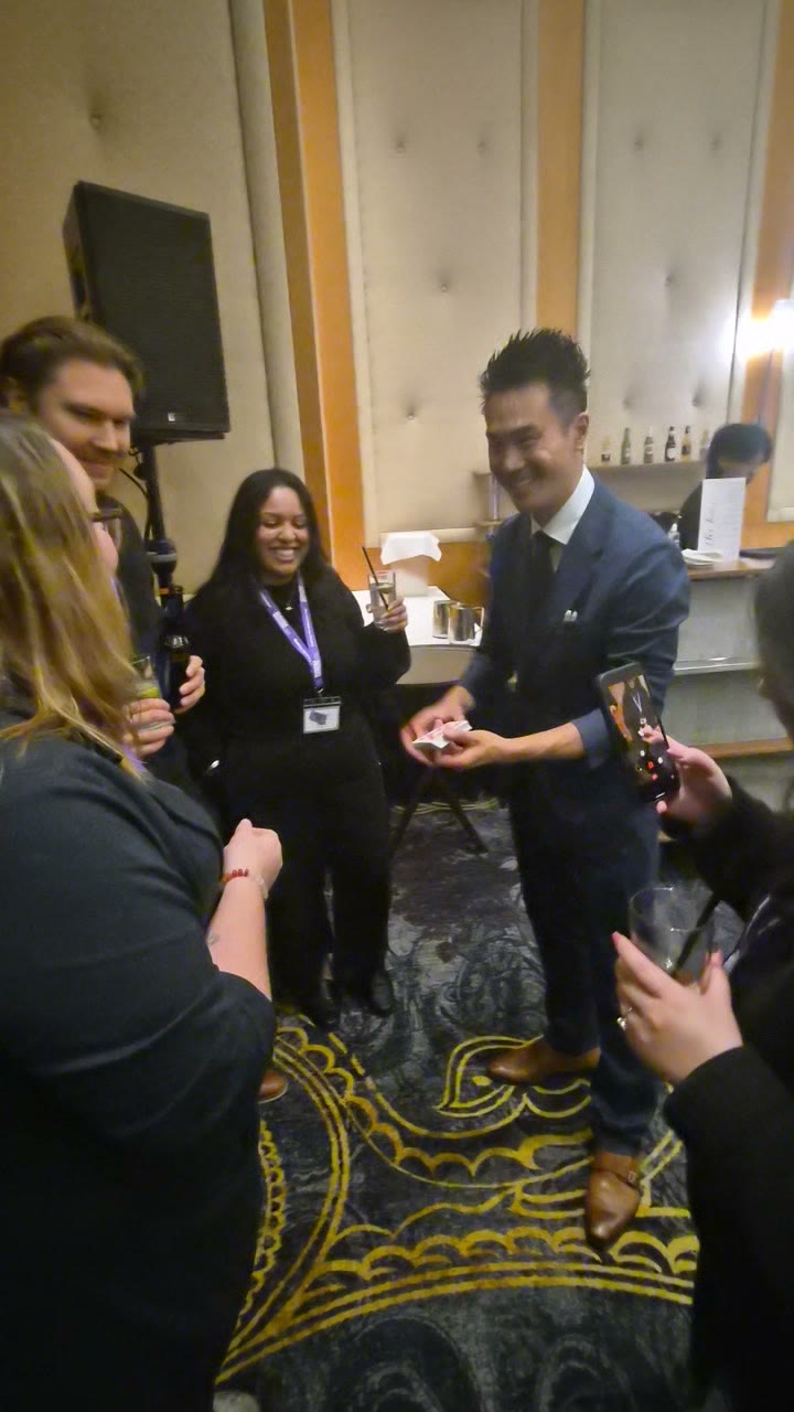 A Beem Wealth guest grinning in disbelief during close-up card magic at the Delta Hotels, Grand Villa Casino