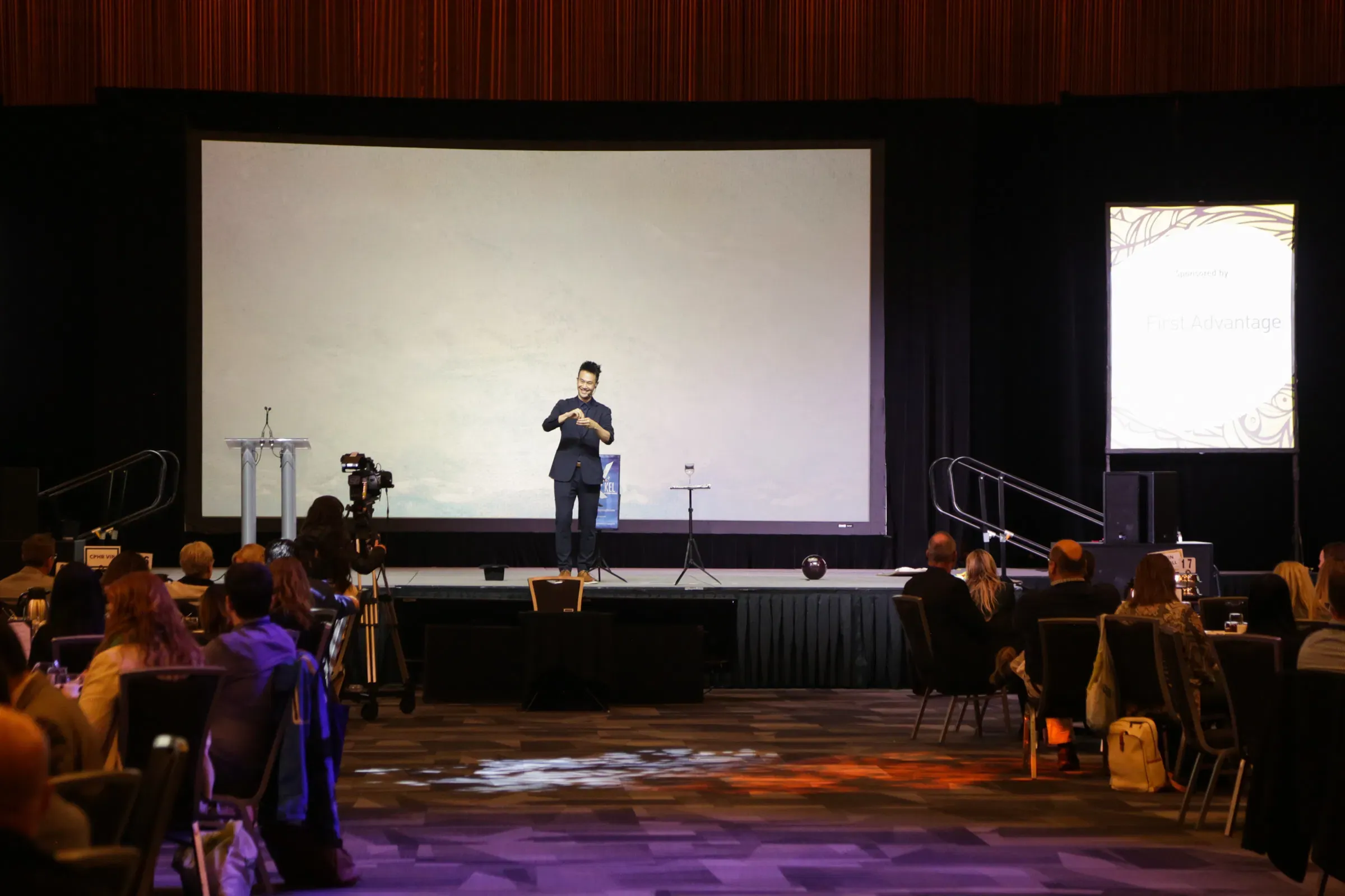 Kel performing on the main stage in front of a full seated audience at a CPHR conference in Vancouver