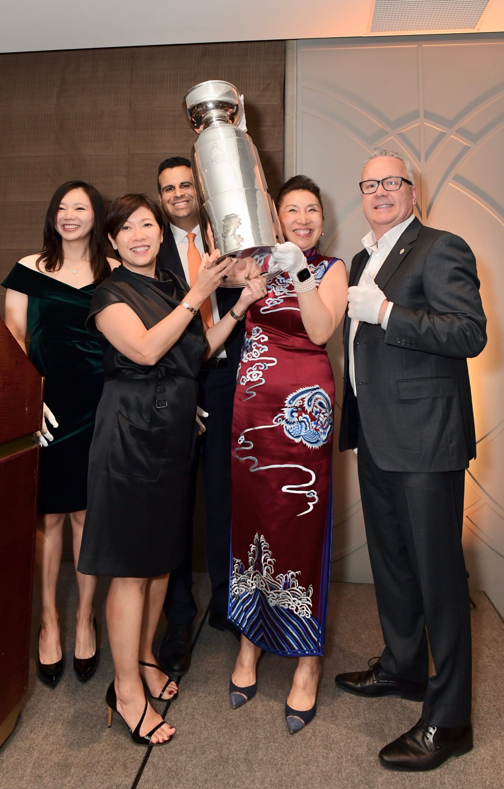 Guests in black tie holding an award and laughing together at a Vancouver gala
