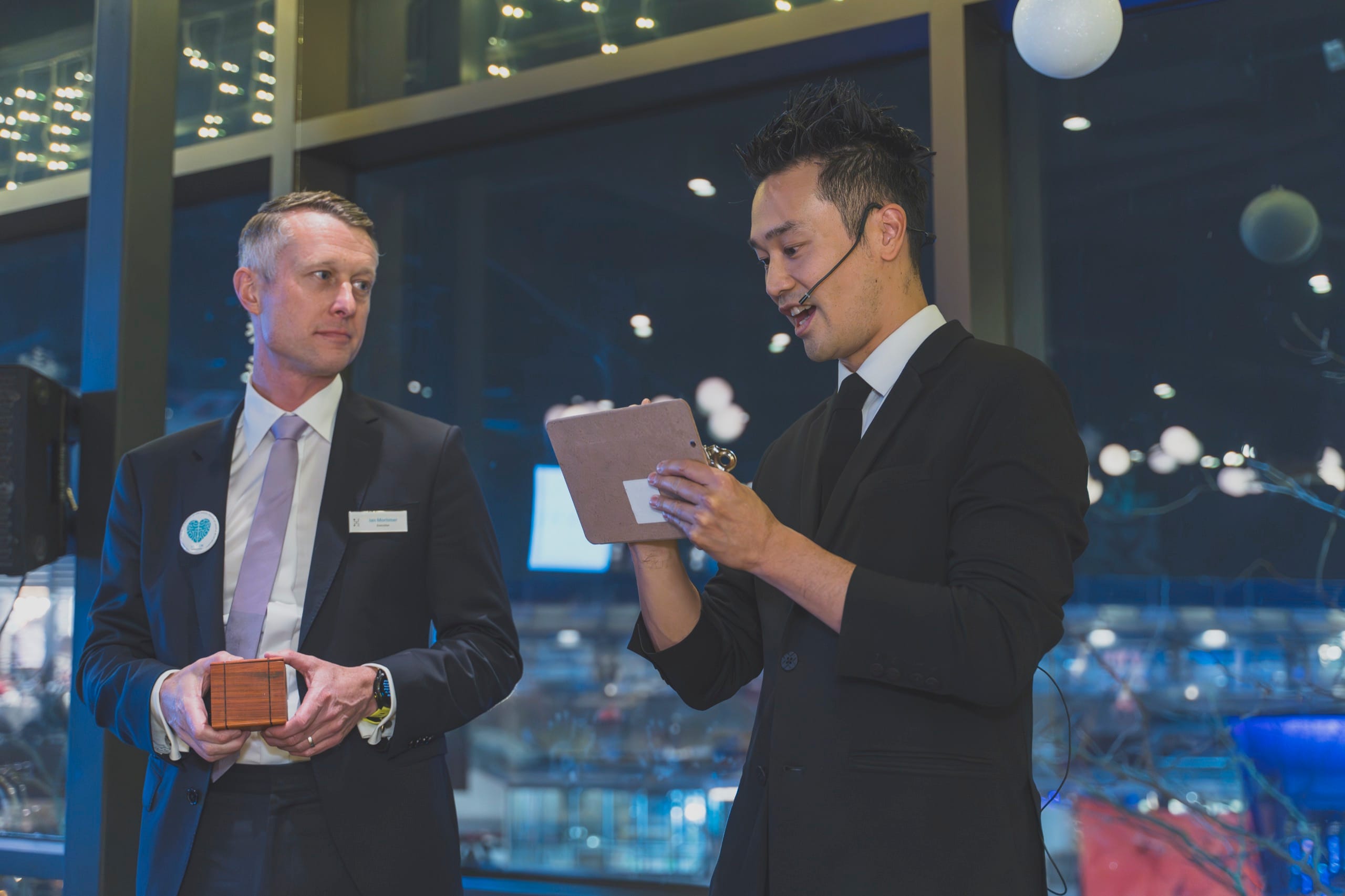 An executive holding a sealed prediction box during a mentalism performance at a Vancouver corporate event